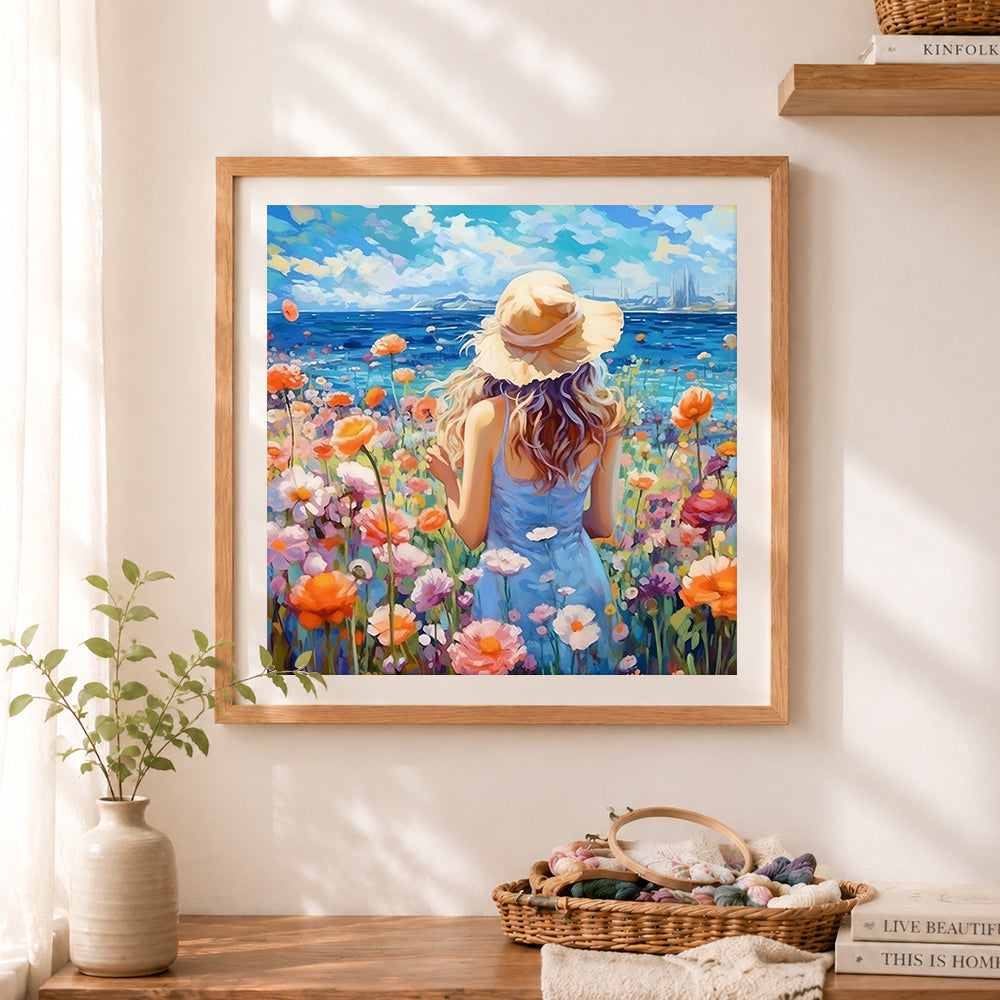 Finished woman in floral field by the ocean cross stitch artwork displayed as home decor