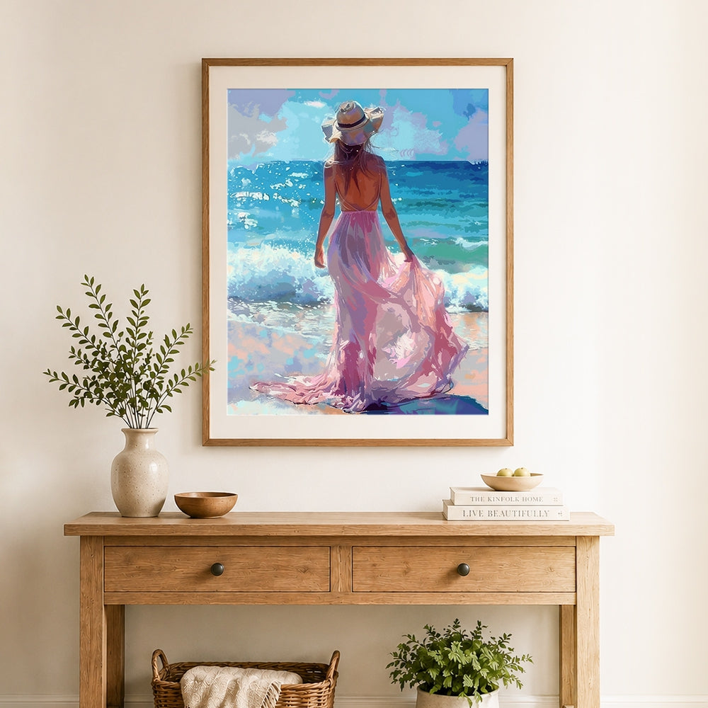 Finished woman in pink dress on beach cross stitch artwork displayed as home decor