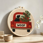 "Woof" red truck with dog punch needle artwork displayed on a table