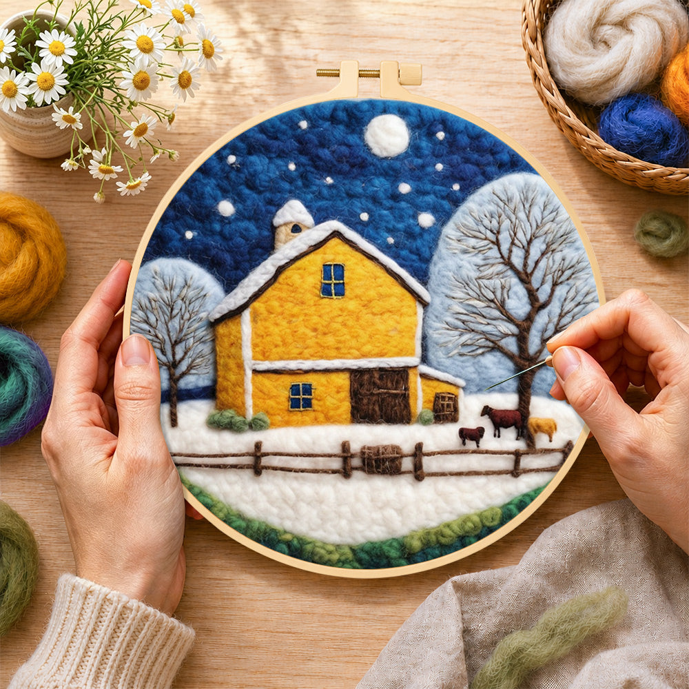 Creating the yellow barn and white trees under the winter moon wool painting by hand with a felting needle