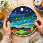 Creating the yellow tower house and rolling green clouds wool painting by hand with a felting needle