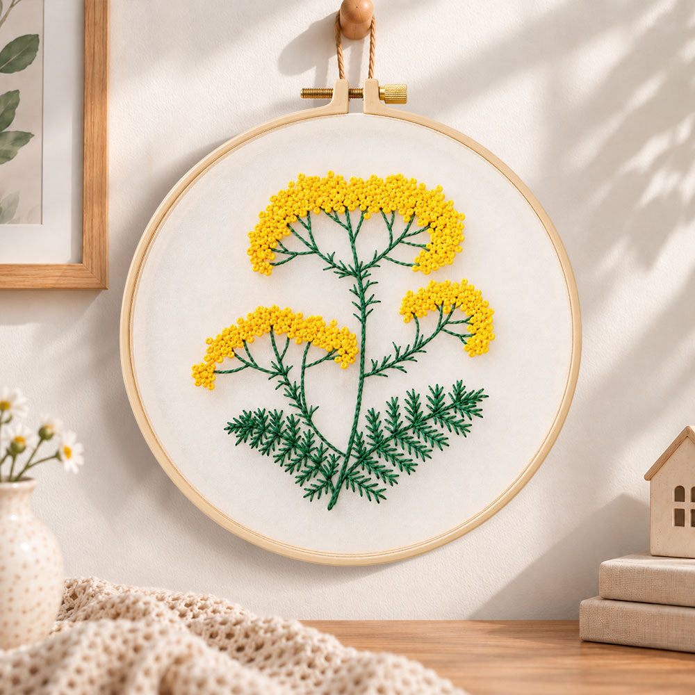 Yellow wildflower stem embroidery hoop wall art displayed as warm and cozy handmade home decor